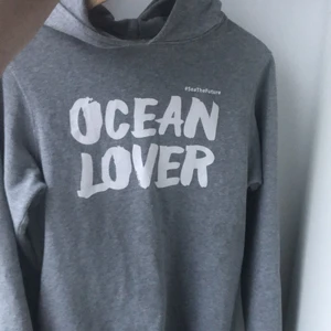 Grå hoodie strl S - Lite lång på mig som är 160cm. Gjord och köpt i Portugal. Jag har ägt den i ca 2,5 år. Den är rätt så använd, den enda defekten den har är att sömen gick upp vid halskragen, men det har jag sytt ihop och det är inget som direkt syns. Säljer för att jag inte använder den längre. Den är ljusgrå med vit text. Köparen står för frakt. Egna bilder🥰