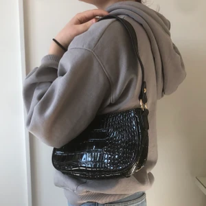 Väska  - En svart lack väska med ormmönster med guld detaljer 