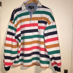 Långärmad piké  - Randig långärmad piké i kraftigt bomullstyg från Grizzly Collection. Storlek L. Litet märke nere framtill, därför lägre pris.