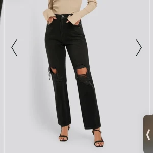 Svarta straight byxor med hål  - Black straight fit jeans från NA-KD i storlek 36. Väldigt fina byxor men tyvärr var de för små för mig vid midjan. Har aldrig använt dem bara prövat.  Kostar 300 kr ink frakt. Ordinarie pris 500kr. 