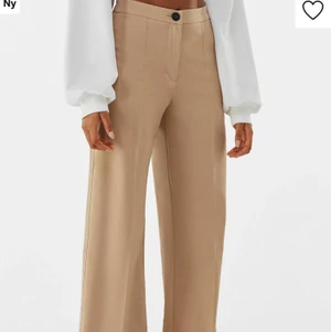 Bershka byxor beige - Super luftiga snygga byxor nu till våren och sommaren. (Passar även vid vinter) beiga ”kostym” byxor, de är ordentliga i materialet, inte genomskinliga och stängs med en knapp framtill. De är långa i benen, även för mig som är 1.73 (med långa ben) slutar de nedanför foten vilket är väldigt trendigt just nu. Säljer dessa då jag har ett liknande par och känns onödigt att ha två stycken🥰 de har även pressveck framtill som går att stryka till för att de ska bli synligare! Dessa passar även en normal 36 då de på zalando även rekomemderade att gå upp en storlek. Använda ett fåtal gånger