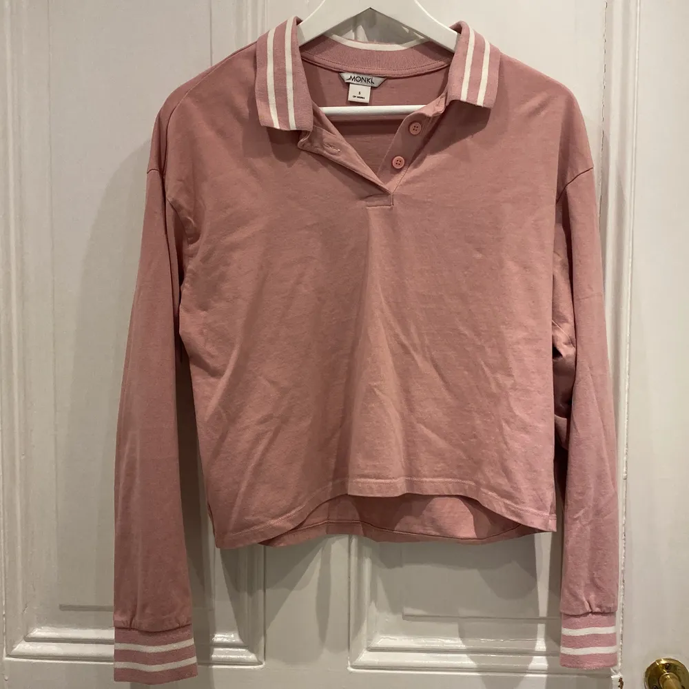 Sparsamt använd rosa tröja från Monki, lite loose fit, med knappar och vita ränder på kragen samt ränder på ärmsluten. . Tröjor & Koftor.