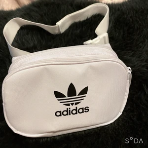 Adidas bälteväska - En helt ny och oanvänd adidas bälteväska i färgen vit som har två fikor och justerbara band så kan därför passa alla. Köpte den för några månader sen men har aldrig använt den för någon anledning. Funkar att ha runt midjan eller vid bröstet… ops! glöm inte att köparen står för frakten 