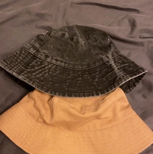 Bucket hat, ONESIZE - 2 st bucket hat en grå/svart och en brun/beige. Säljer pågrund av att de aldrig har kommit till användning och är därför i nyskick.