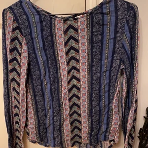 Blus/tröja storlek XXS/XS - Jättefin mönstrad blus/tröja från H&M i storlek XXS men skulle också passa en XS. Har knappar som följer ryggraden som gör det lite öppet vid ryggen. Använd. Men i gott skick.