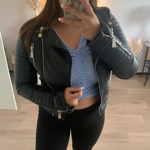 Jacka från chiquelle  - Supercool Jacka från chiquelle, helt oanvänd. Storlek 38. jackan är i läderimitation med quiltade detaljer på axlar och i ärmslut. Två fickor med dragkedja framtill. Reglerbara bälten på sidorna. Köpt för 700 buda från 200 och frakt tillkommer.  