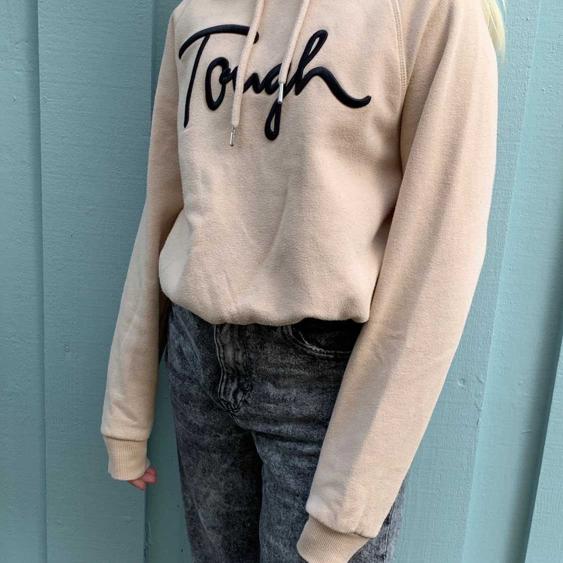 En beige Hoodie med svart text på