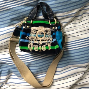 Äkta juicy coutureväska!! - Säljer en chick liten juicy couturväska för att den tyvärr inte kommer till använding längre 💙💚🤍Jättefin och bra om man bara ska ha få saker med sig! Kommer med en axelrem så man kan ha den på lite olika sätt. Flera fack, skriv görna för fler bilder. I mycket bra skick!💕💕 OBS: budgivning!!! Senaste bud: 500💕💕 minst 10 kr mellan buden❤️