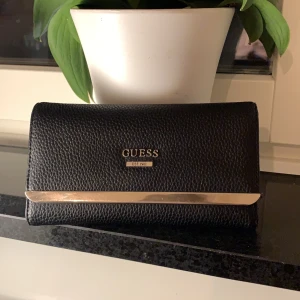 Guess plånbok - Äkta plånbok från guess. Köpte den på outlet i usa men kostar på deras hemsida 59€. Finns myntfack, 12 kortfack och andra fack. Kan mötas i Stockholm annars står köparen för frakten🥰💕