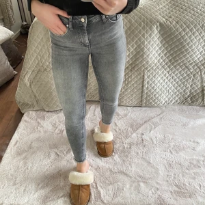 Gråa jeans  - Raka jeans i en så fin grå färg. Slitningar nere vid ankeln. Jag är 162cm. Köparen står för eventuell frakt. 