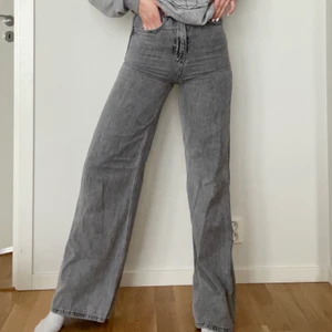 Grå jeans  - Jag säljer ett par grå långa vida jeans från Stradivarius, super snygga sitter som ett smäck. (Jag är 1.70 på bilden) jeansen är i storlek 34. Använda 1 gång endast!