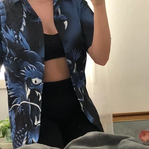 Blå svart kortärmad skjorta - Kortärmad skjorta med drakmönster💙💙 super cool men aldrig använt💙🖤 frakt tillkommer
