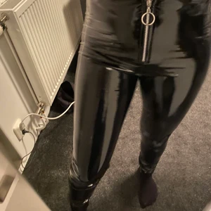 Lackbyxor - Tighta svarta lackbyxor från Nelly one med kedja längst fram. Storlek S