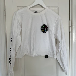 Croppad tröja med tryck  - Snygg croppad långärmad tröja med tryck på ryggen, ena armen och ett litet på bröstet. Från Bershka, bra skick! Spårbar frakt med DHL inräknad i priset!