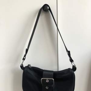 super trendig och söt svart väska med band som går över ena axeln, är 6 månader gammal och köpt helt ny! Väldigt sällan använd. Köpt för 300kr