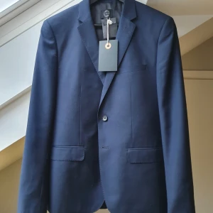 Ny kostym Suit Tailoring, lappar kvar - Marinblå. Använ. Jag är 177/68, kavajen sitter perfekt, byxorna för tighta tyvärr. Annars skulle aldrig sälja. Polyester, mycket fin och stilig. Nypris var 1500