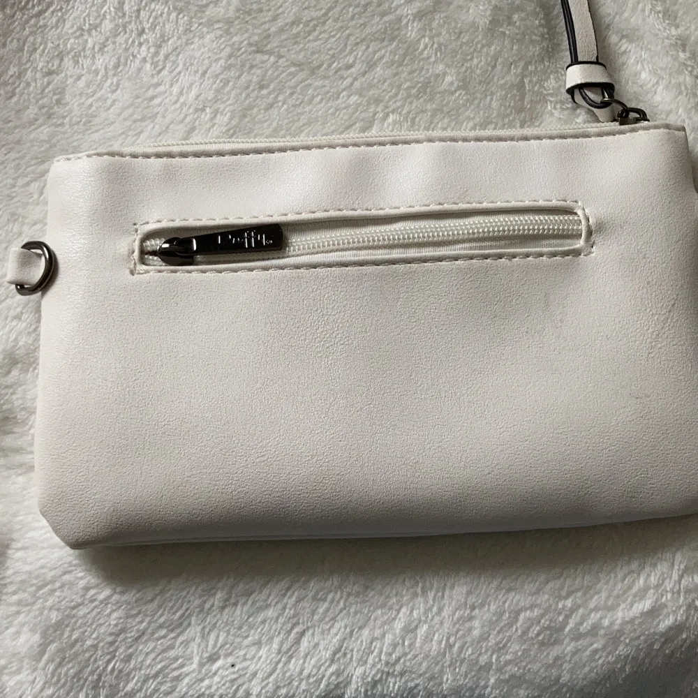 En vit Duffy väska med fickor både utanpå och inuti ( nypris 200kr ) det finns både ett kort band för handväska och ett långt band till axelväska💓 använd en gång. Väskor.