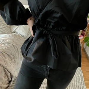 Svart blus från NAKD🖤 - En svart, v-ringad, off-shoulder blus från NAKD med avtagbart band i midjan. Oanvänd med prislapp kvar.