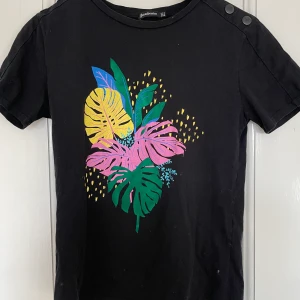 T-shirt  - T-shirt med coolt tryck från Stradivarius, det gröna på trycket är i sammet. Bra skick. Spårbar frakt med DHL inräknat i priset!!