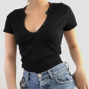 Svart Crop Top - 🌍JAG BJUDER PÅ FRAKT🌏 Snygg t-shirt med knappar som jag aldrig använt och säljer eftersom jag inte gillar hur urringad den är. Skit fin till ett par jeans eller kostymbyxor! Tveka inte på att skriva till mig vid frågor eller om du vill pruta :) 