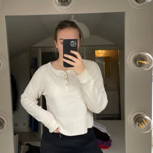 Vit tröja från A&F - Snygg vit tröja från A&F med tre knappar. Bra skick, spårbar frakt med DHL inräknad i priset! Passar flera storlekar beroende på hur man vill att den ska sitta.