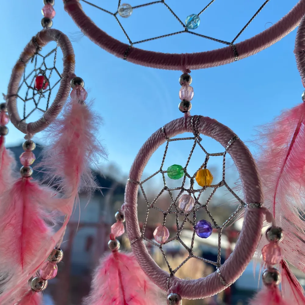 Vacker drömfångare med fina pärlor och fina rosa fjädrar!✨☀️med ett brunt snöre så den kan hängas upp. 160+frakt. Övrigt.