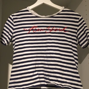 Randig t-shirt - Vit och svart randig tröja med texten ”new york” i rött