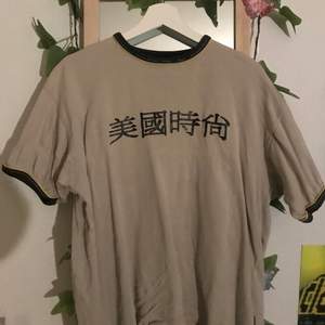 Ascool t shirt med kinesiska tecken i beige färg och oversized modell🔮 