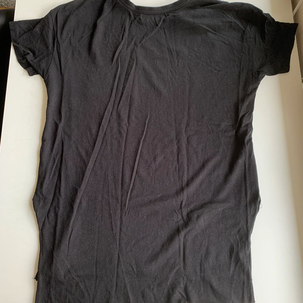 Svart t-shirt med en liten fick på vänster sida. På det vita trycket står det ”Save the earth It is the only planet with chocolate”. Längre tyg bak och en liten slits i sidan. Fint skick och super skönt material. Stl XS från Bershka. Tröjan koster 30 kr, frakt ingår ej. Swipe för fler bilder.. T-shirts.