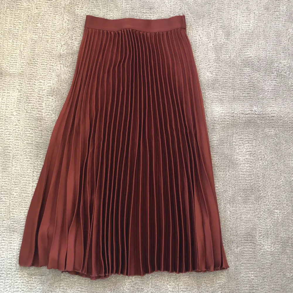 En superfin rödbrun plisserad långkjol från HM i storlek 34, säljer på grund av att den har blivit för liten💕 Pris 100 kr frakt ingår inte. Kjolar.
