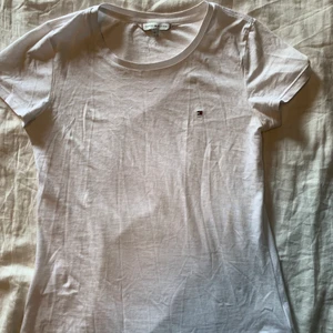 Tommy Hilfiger T-shirt - Säljer en vit hilfiger T-shirt st xs men den sitter mer som en S, köpt för 450kr säljer för 150