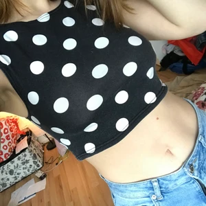 Prickig crop top i stl. 36 - Söt, svart crop top med vitpickigt mönster. Stretchigt material, bomull. Fin passform, tajt fit. Använd ganska mycket men är fortfarande ur riktigt fint skick. Fraktkostnad tillkommer efter att jag vägt paketet (om det ska postas) och vet hur mycket det blir.
