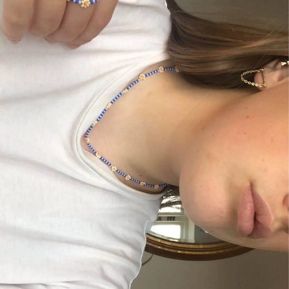 Handgjordast halsband med matchande ring i två nyanser av blått med blommor i pärlemor. Standardspännen på halsbandet. Frakt ingår i priset <3. Accessoarer.
