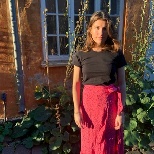 Pink ganni nederdel - Pink ganni nederdel med små sorte blomster. Slå om og flæsekant