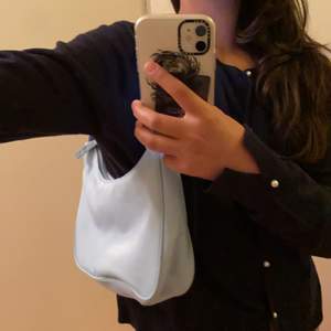 Jag säljer en blå axelväska från monki. Väska är i ny skick har aldrig använt passar till alla personer.