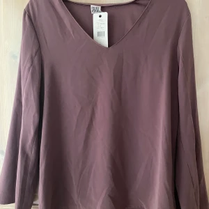 Saint Tropez blus - Mörklila blus från Saint Tropez. Aldrig använd innan, lapp kvar. Slits i armarna 