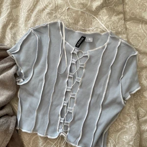 Topp - Ljusblå / vit topp från H&M i storlek M. Aldrig använd. Köparen står för frakt