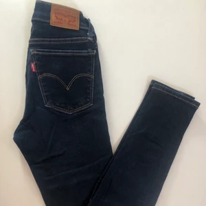 Levis super skinny jeans - Säljes då de blivit försmå. Väl använda och har en lagning över vänster bakficka (se andra bilden), men den tänker man inte på. Frakt ingår inte och kolla sista bilden för att se hur färgen är i verkligheten🥰