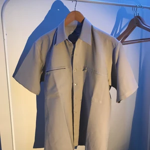 Skjorta - En vintage sandbeige skjorta i medium, oversized fit för en small. En ficka med dragkedja på vardera bröstplatta.