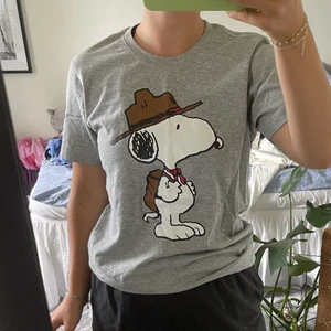 Grå T-shirt med tryck  - Cool grå T-shirt med peanuts tryck. Bra kvalitet och inte använd mycket, därav är den i mycket bra skick. Köparen står för frakt. 