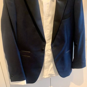 Smoking storlek 46 - Mörkblå Smoking av märket These Glory Days inköpt på Volt för 3000kr. Har endast använt den en gång på nyårsafton. Komplett med skjorta, byxor och resegarderob. Hämtas och provas i Västerhaninge men kan även leverera inom Stockholm för en skälig summa.