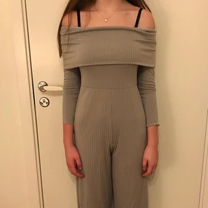 Off shoulder grå byxdress - Super snygg ljusgrå byxdress med väldigt bekvämt material. Oanvänd och säljs då jag köpte en för liten storlek. Nypris 600kr men säljer för 200kr! Köpare står för frakt. 