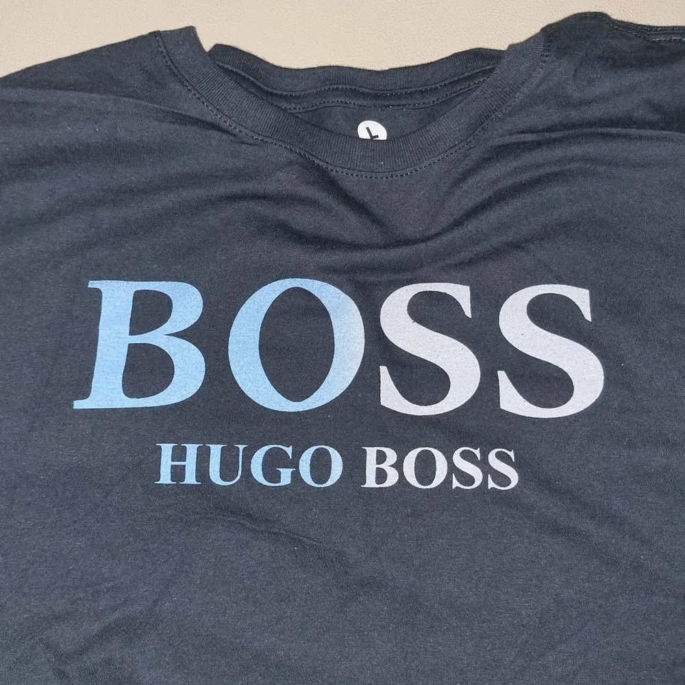 Ytterligare en oanvänd Hugo Boss t-shirt med centrerad text och svartblå bakgrund. Simpel design fu kar med det mästa. Framhäver dina armar och är väldigt behaglig att ha på sig.       (!Tar häldst swish!). T-shirts.