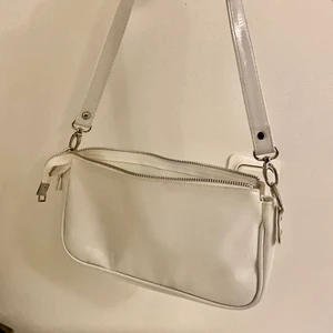 vit väska - Vit väska ifrån prettylittlething, aldrig använd. Skriv för mer bilder! Har ett stort fack samt 2 små där ena har en dragkedja💓 pris kan diskuteras