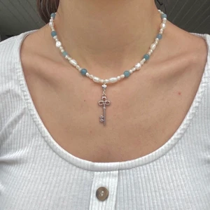Nyckelhalsband - Handgjort halsband av mig, halsbandet har en silvrig nyckel berlock🗝🤍 Halsbandet är gjort av äkta sötvattenspärlor och halvädelstenen aquamarine. Halsbandet har en 5cm lång förlängningskedja i rostfritt stål som är silverpläterat. Stenen aquamarine står för mod tydlighet i vår kommunikation, renhet och klarhet.💙 Kontakta mig om du har frågor eller vill köpa🥰❤️
