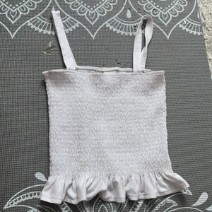 Vitt linne med volang - Säljer detta linne pågrund av att det inte kommer till användning. Det är ett vitt men en volang. 