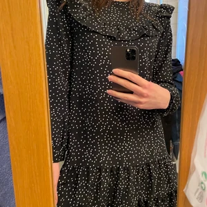 Långärmad prickig klänning - En superskön långärmad klänning med volanger och prickar i svart och vitt 🖤🤍 storlek M men passar även S!