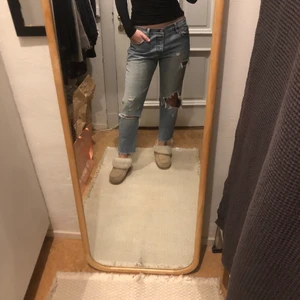 Baggy levis jeans - Ett par par Levis 501, låg midjade, ljusblåa och slitningar.