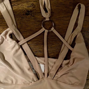Rebecca Stella body, nyskick! - Ännu ett plagg som enbart blivit liggandes. Tyvärr. Supercool, ljust puderrosa body med remmar och detaljer från R. Stella. Strl XS. Säljes pga flytt/platsbrist. Tagen är dock avklippt. Stretchigt tyg!