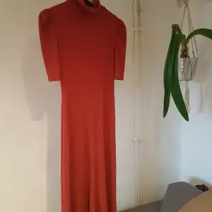 Beautiful stretchy orange dress, with a high neck and a small puff at each sleeve. Only worn once.